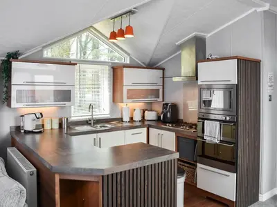 a kitchen with white cabinets and a large island at Solway Escape in Plumbland