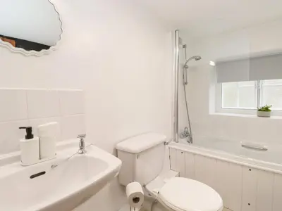 a white bathroom with a toilet and a sink at One Side House Farm in Ambleside