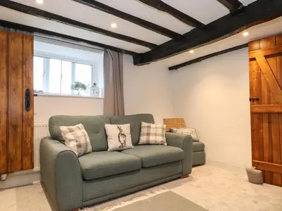 a living room with a green couch and a window at Two Side House Farm in Ambleside