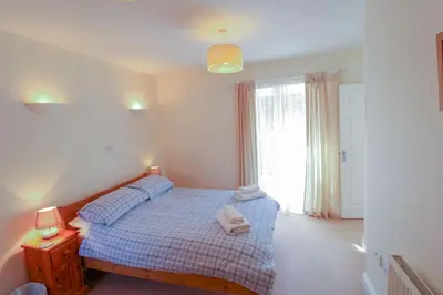 a bedroom with a bed and a large window at Bramble Cottage perfect for a relaxing romantic break in Keswick in Keswick