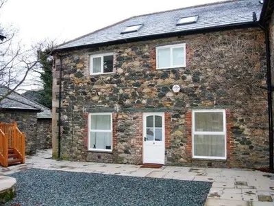 a brick house with a white door and windows at Bramble Cottage perfect for a relaxing romantic break in Keswick in Keswick