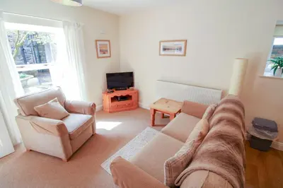 a living room with a couch and chairs and a television at Bramble Cottage perfect for a relaxing romantic break in Keswick in Keswick