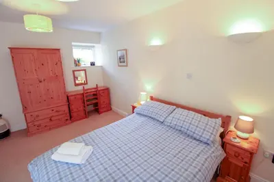 a bedroom with a bed with a blue and white bedspread at Bramble Cottage perfect for a relaxing romantic break in Keswick in Keswick