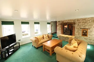 a living room with two couches and a tv at The Gardeners Cottage, Hutton John is a luxurious cottage with hot tub 10 minutes from Lake Ullswater in Penruddock