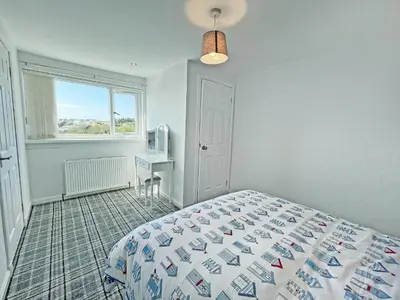 a bedroom with a bed and a window at Driftwood Cottage in Portpatrick
