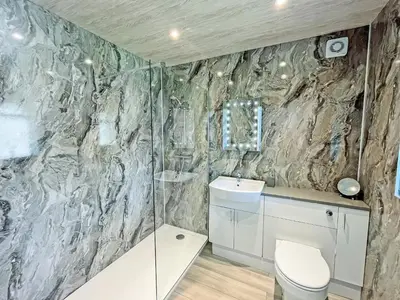 a bathroom with a shower and a toilet and a sink at Driftwood Cottage in Portpatrick