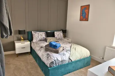 a small bedroom with a bed with a blue frame at Quirky & Comfortable Residence in Workington