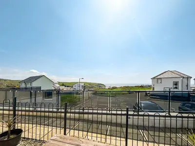 a view of a parking lot with houses and a car at Sandpipers in Portpatrick
