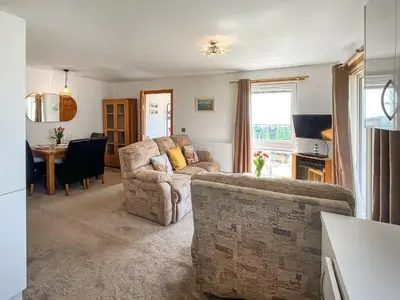 a living room with two couches and a table at Sandpipers in Portpatrick