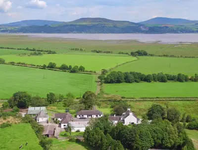 an aerial view of a house in a green field at Courtyard Cottages, Garden Cottage in Wigtown