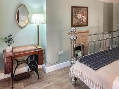 a bedroom with a bed and a table and a mirror at Darroch in Moniaive