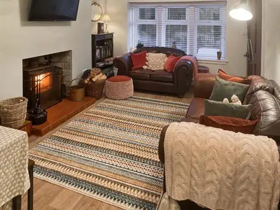 a living room with a couch and a fireplace at Darroch in Moniaive