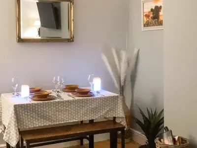 a dining table with candles and plates and a mirror at Darroch in Moniaive