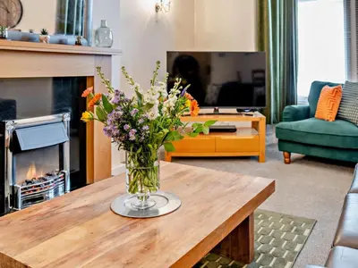 a vase of flowers on a table in a living room at 2 Bed in Keswick oc-94995 in Keswick