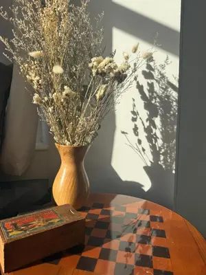 a vase with dried flowers and a box on a table at Shemara rooms in Keswick