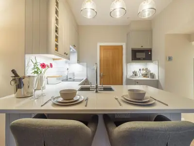 a kitchen with two chairs and a table with two plates at Gingerbread Nook in Grasmere