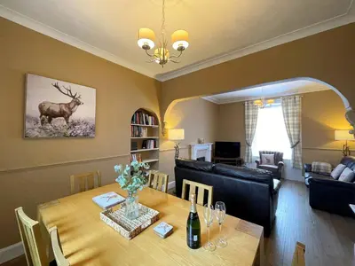a dining room with a table with a deer on the wall at Beautiful House With Stunning Views Kirkcudbright - Pass the Keys in Kirkcudbright