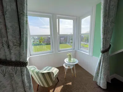 a room with two windows and a chair and a table at Beautiful House With Stunning Views Kirkcudbright - Pass the Keys in Kirkcudbright