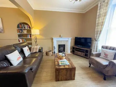 a living room with a leather couch and a coffee table at Beautiful House With Stunning Views Kirkcudbright - Pass the Keys in Kirkcudbright