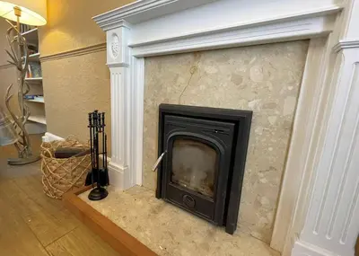 a fireplace in a room with a stone wall at Beautiful House With Stunning Views Kirkcudbright - Pass the Keys in Kirkcudbright