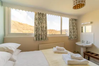 a bedroom with a bed and a sink and a window at Le Tholonet in Grasmere