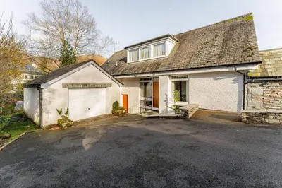 a house with a garage and a driveway at Le Tholonet in Grasmere
