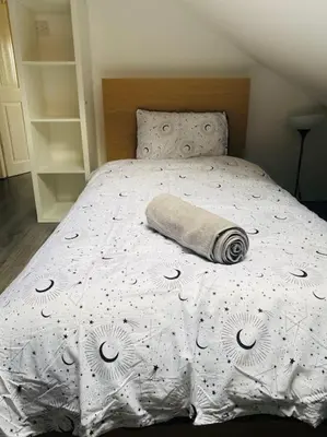 a bed with a comforter with a roll on it at Golfers lovers! Near all famous golf courses in Prestwick