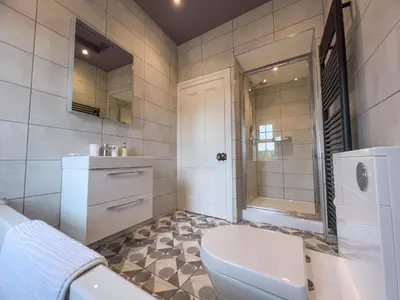 a bathroom with a toilet and a shower and a sink at High House Cottage, Southwaite in a rural setting with garden, BBQ & hot tub in Southwaite