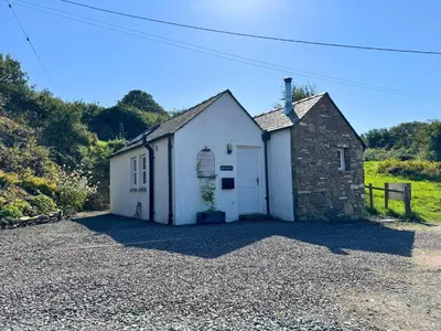 a small white building in a gravel driveway at Birds Nest in Gatehouse of Fleet