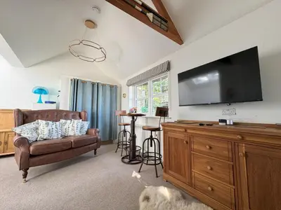 a living room with a couch and a flat screen tv at Birds Nest in Gatehouse of Fleet