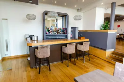 a bar in a restaurant with bar stools at Opul Boutique at Admiral House in Douglas
