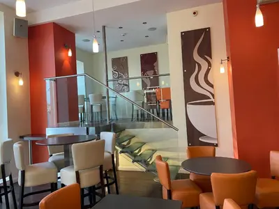 a restaurant with two tables and chairs and a staircase at Opul Boutique at Admiral House in Douglas