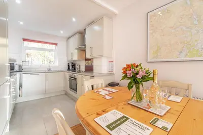 a kitchen with a wooden table with a vase of flowers on it at Number One in Chapel Stile