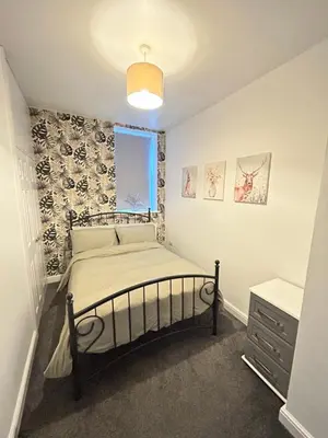 a small bedroom with a bed and a window at Central apartments in Carlisle