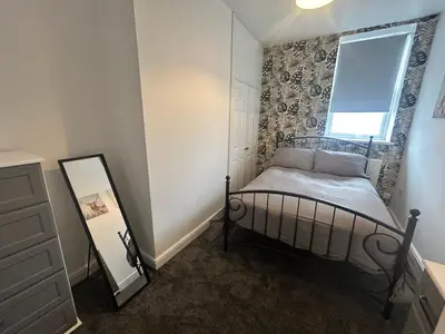 a small bedroom with a bed and a window at Central apartments in Carlisle