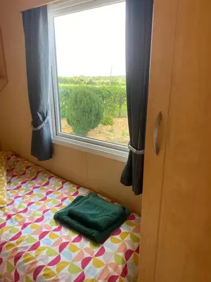 a bedroom with a bed with a window and a green pillow at 23 The Beeches in Gilcrux