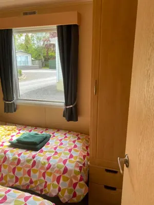 a bedroom with a bed with a window at 23 The Beeches in Gilcrux