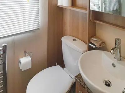 a bathroom with a white toilet and a sink at Stream Side View in Lamplugh