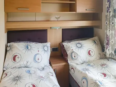 a small bedroom with a bed and pillows at Stream Side View in Lamplugh
