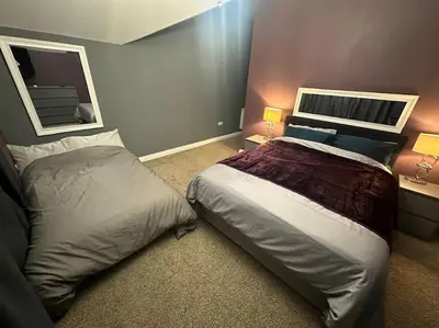 a bedroom with a large bed and a mirror at The hot tub by the waterfall - facilities included in Lower Foxdale