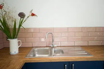 a kitchen sink with a vase with flowers in it at Bird Nest - dine with the eagles Private Retreat in Carlisle
