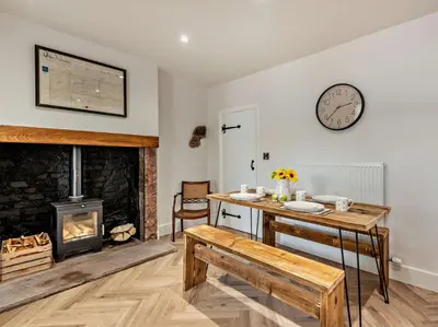 a living room with a table and a fireplace at 2 Bed in Arlecdon 95126 in Arlecdon