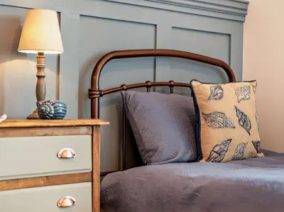 a bedroom with a bed with a lamp and a dresser at 2 Bed in Arlecdon 95126 in Arlecdon