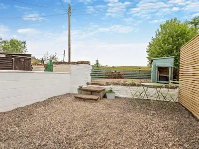 a patio with a bench and a table and a building at 2 Bed in Arlecdon 95126 in Arlecdon