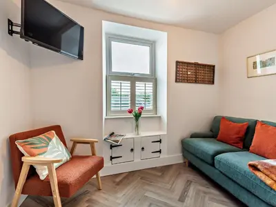 a living room with a green couch and a window at 2 Bed in Arlecdon 95126 in Arlecdon