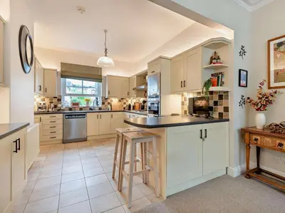 a large kitchen with white cabinets and a counter at 3 Bed in Keswick oc-95032 in Keswick