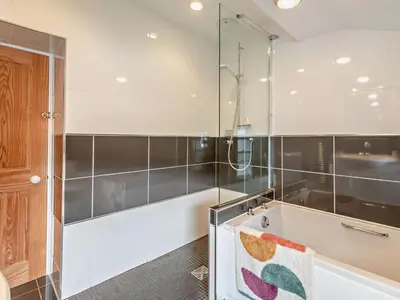 a bathroom with a shower and a towel on a tub at 3 Bed in Keswick oc-95032 in Keswick
