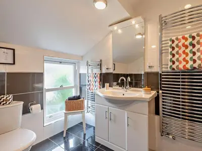 a bathroom with a sink and a toilet and a window at 3 Bed in Keswick oc-95032 in Keswick