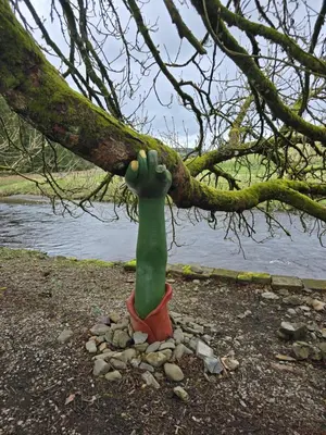 a statue of a hand on a tree branch at Luxury static caravan in Beattock