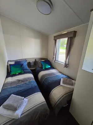 a room with three beds and a window at Luxury static caravan in Beattock